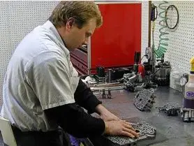 A man working on some parts in a shop.